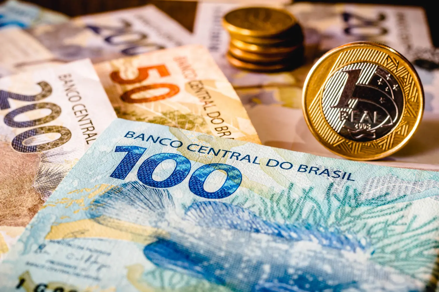 Imagem de cédulas e moedas em real, simbolizando a influência do IBS e CBS para precificação de bens e serviços.