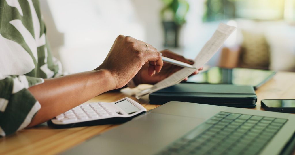 Mulher emitindo uma nota fiscal, destacando o calendário atualizado de prazos para informar IBS e CBS na NFS-e.