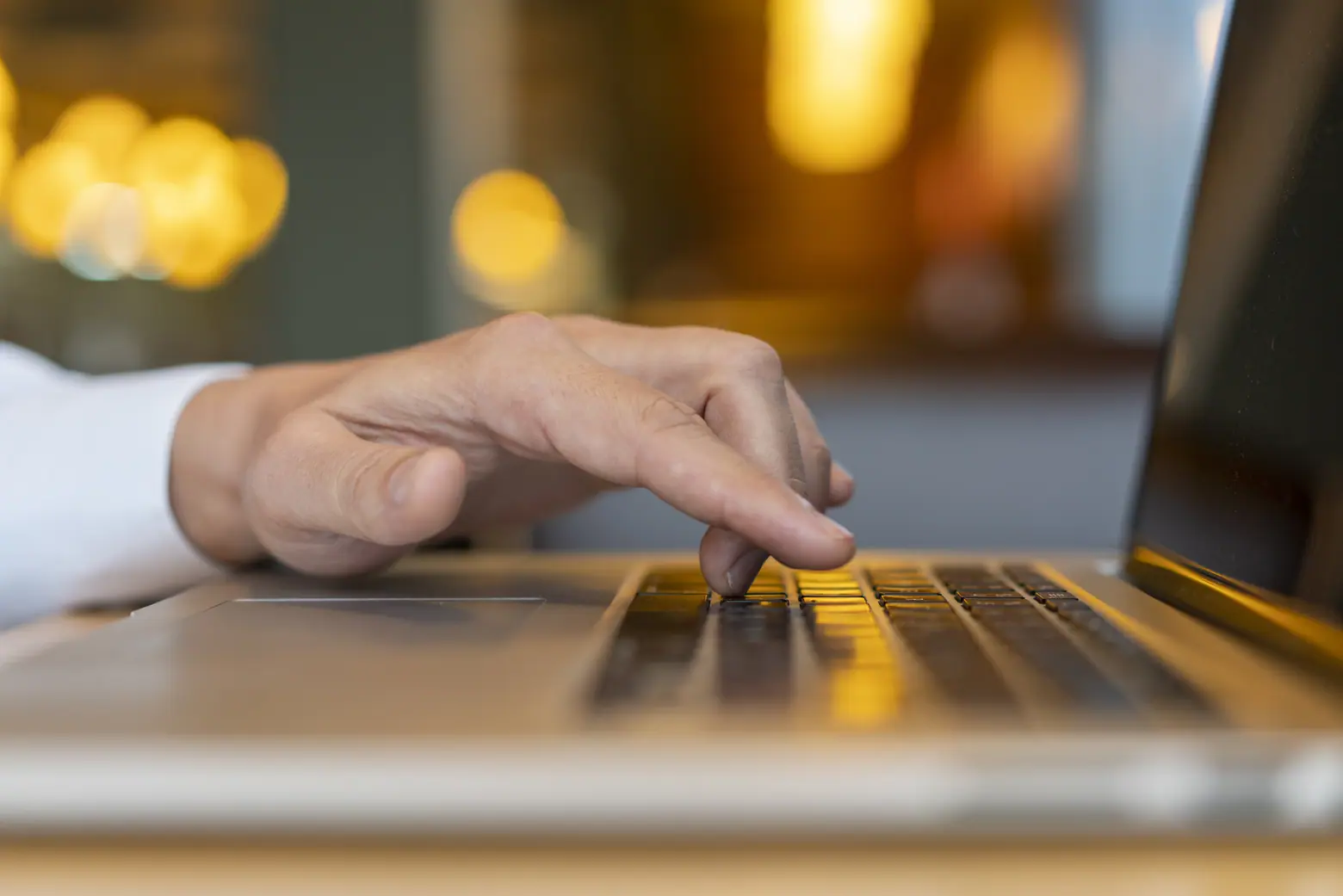 Imagem da mão de um contador digitando no notebook, enquanto registra eventos e evidências no eSocial.